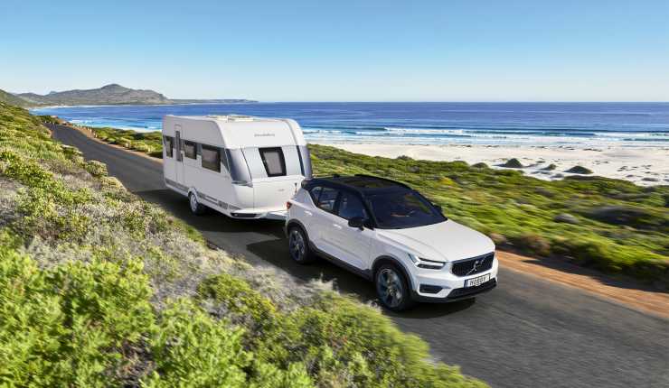 Bil drar husvagn på väg intill havet