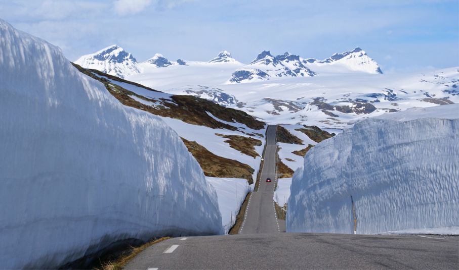 Sognefjellsvägen i Norge. Vindlande väg genom snöigt landskap i Norge
