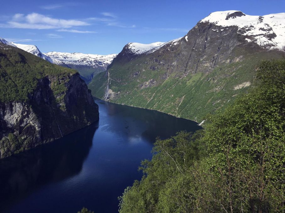 Geirangerfjorden fortsätter ut mot havet och under våren är det extra bra fart i alla vattenfall. Härifrån syns fem av "de sju systrarna" som de största vattenfallen kallas. Ovanför branterna finns även några gamla gårdar som har en högst intressant historia.