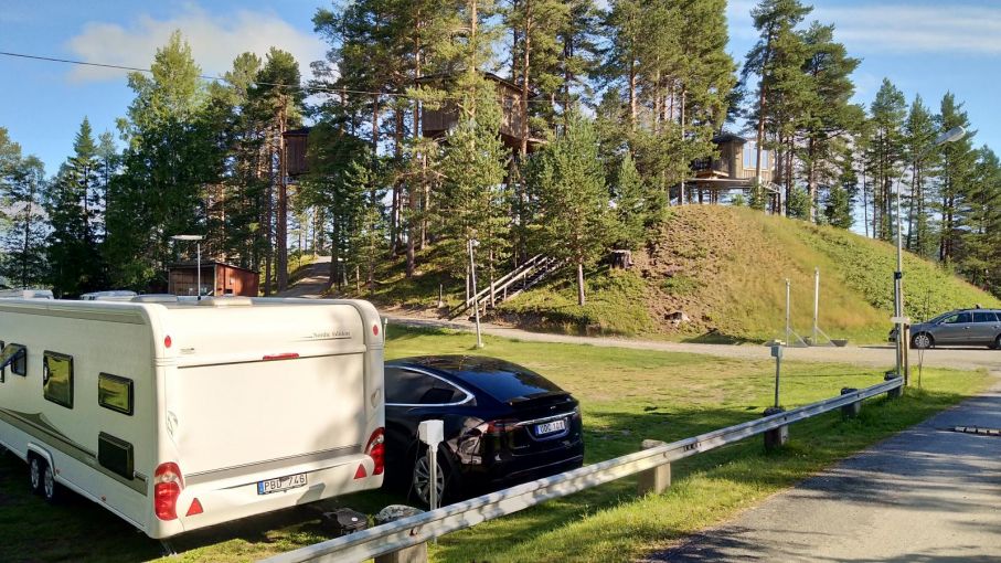 Den barnvänliga sidan av campingen med lekplats och badplats. I skogen på kullen skymtar trädhusen "beckasinerna" som är en udda form av hotell.